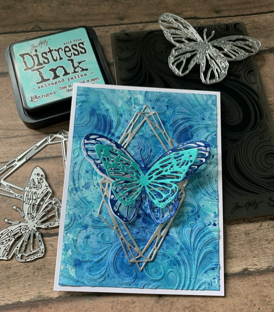 Layered butterflies card surounded by supplies