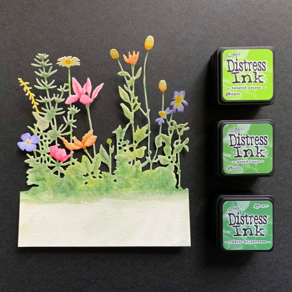 Watercoloring the wildflowers with darker green inks