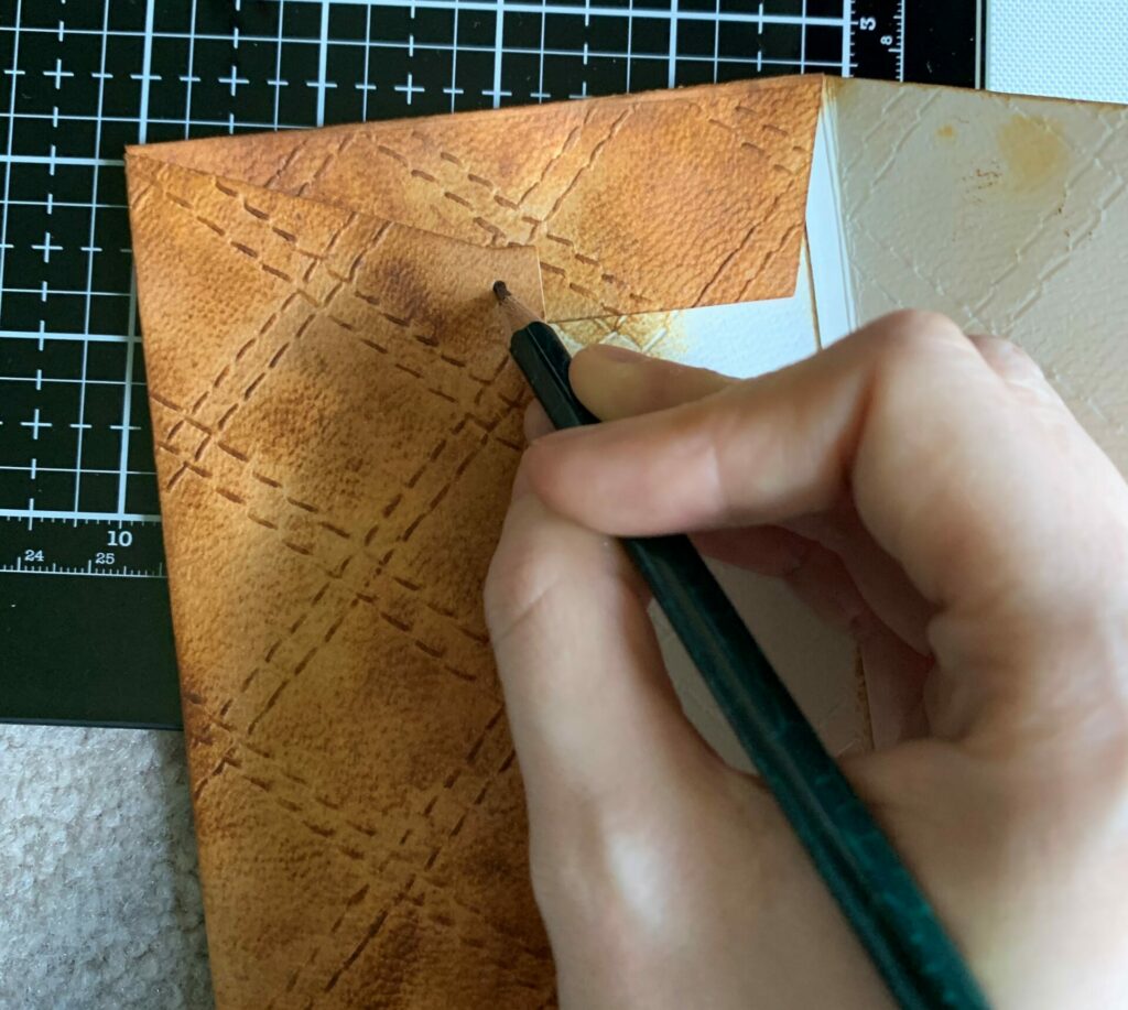 Tracing the brad hole on the quilted leather envelope