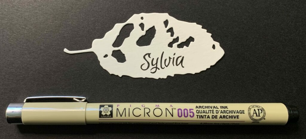 Filling in the traced name with a micron pen